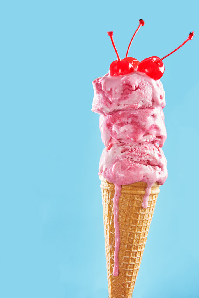 Melting ice cream cone with maraschino cherries