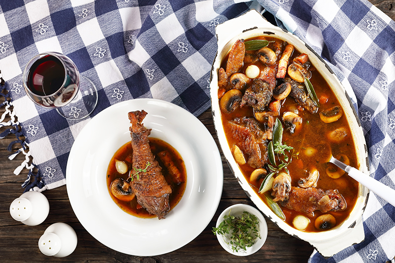 Coq au vin stewed in red wine with herbs