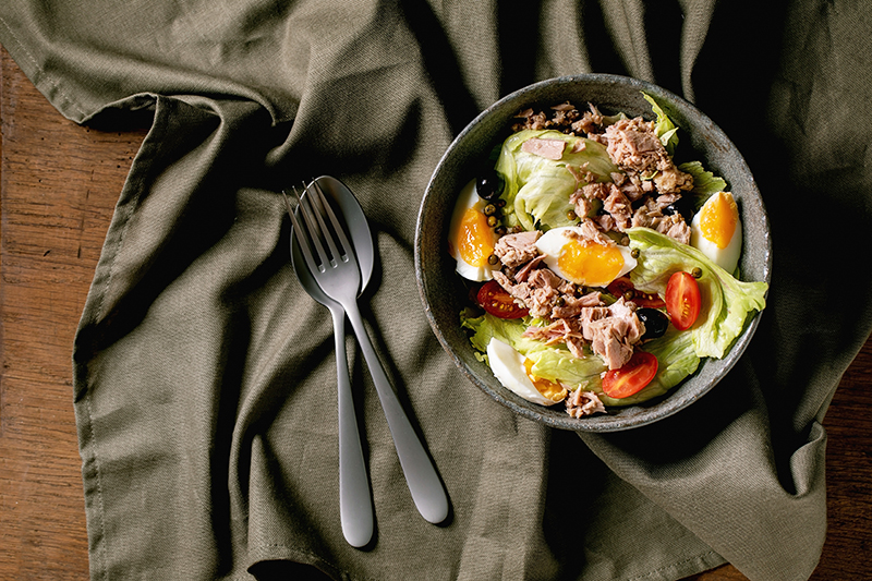 Traditional nicoise salad with canned tuna fish, olives and eggs